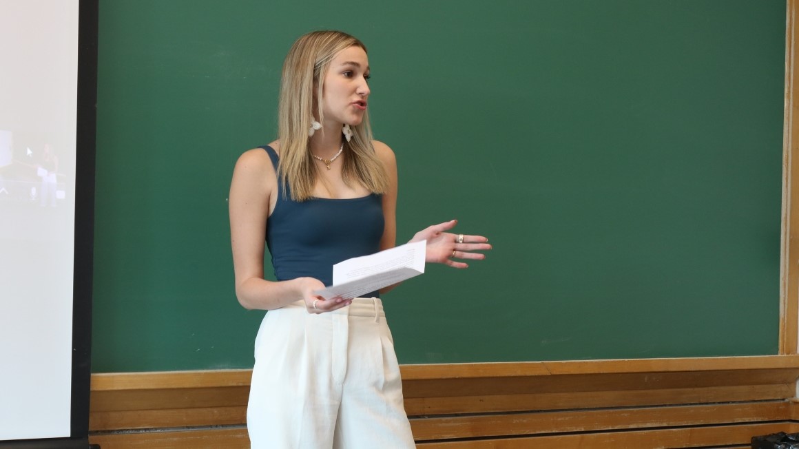 Student presenting in front of a chalkboard.